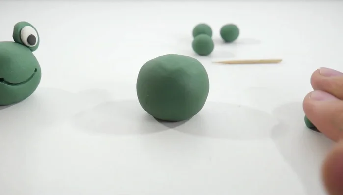 Make the legs: Create four small green clay cylinders for the legs. [135.9]