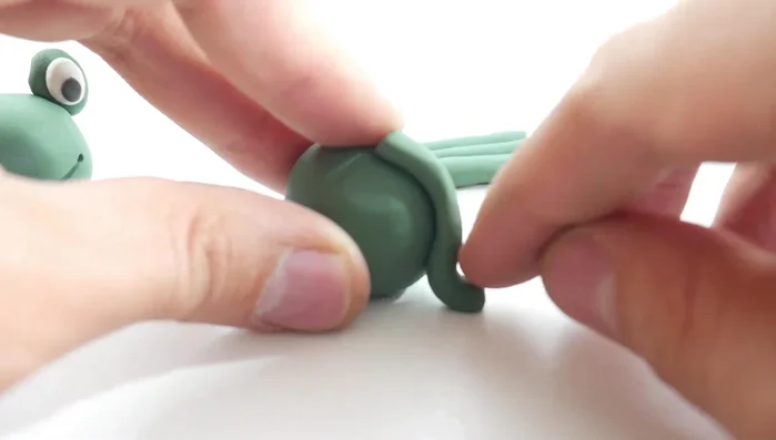 Attach the legs: Attach the front legs to the top of the body, bending them slightly. Attach the back legs similarly, with a more pronounced bend. [155.04]