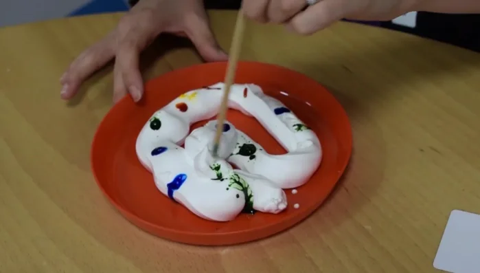 Gently swirl the colors together with a stirrer, avoiding complete blending.