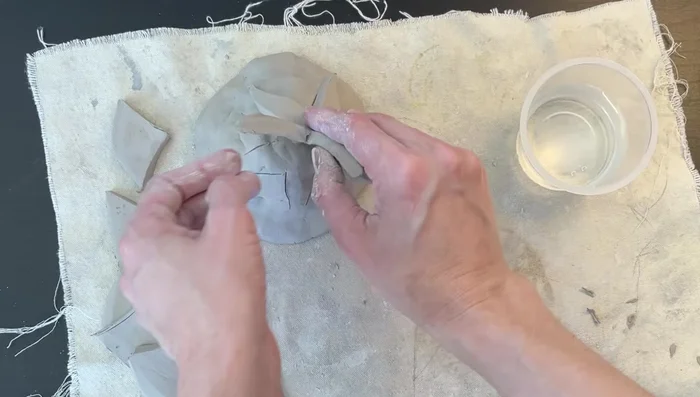 Attach starfish: Score both the mound and the back of the starfish using cross-hatching. Apply water to both scored surfaces, and firmly press the starfish onto the mound.