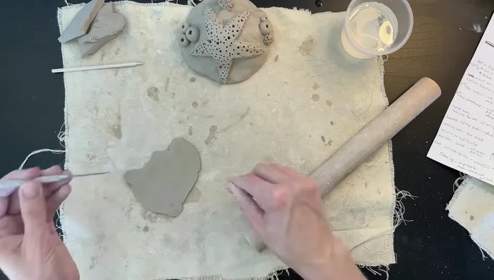 Make cylinders: Roll out thin slabs of clay, cut out squares, and fold them into cylinders. Blend the bases together and attach to the mound.