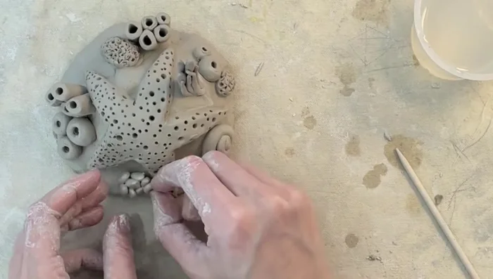 Add Mussel Shells and flat rocks: Shape small clay bits into mussel shells and flat rocks, attach directly to the base.