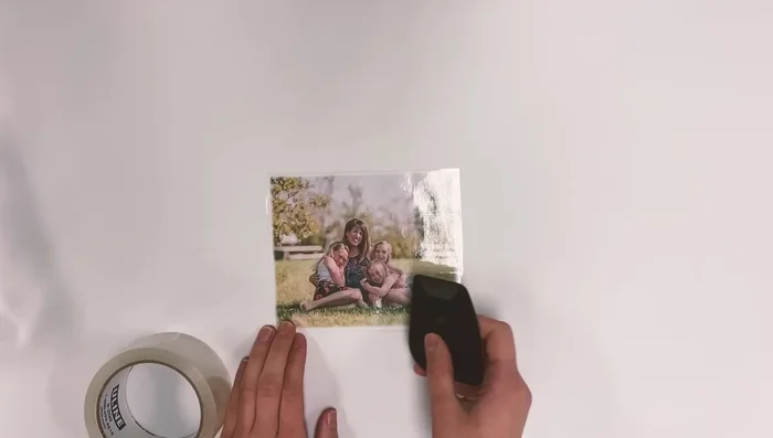 Burnish (rub firmly) the printed side of the photo with a scraper or credit card to ensure good adhesion.