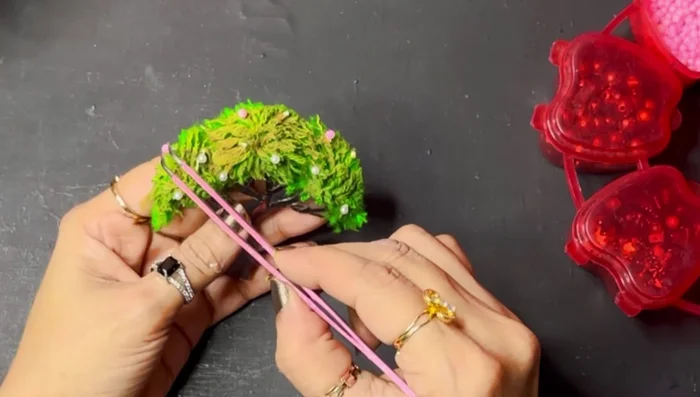 Stick pearl beads (painted or unpainted) onto the tree using a hot glue gun.