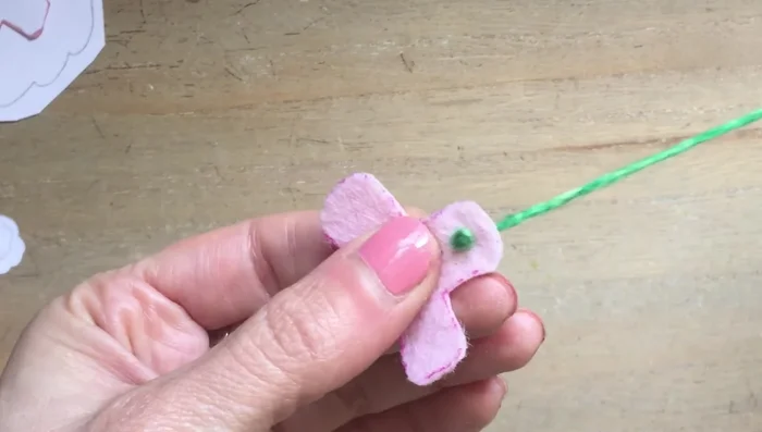 Sew the teacup handle: Start on the inside, pull through, and go back through to the other point. Anchor a tiny bit of felt on the other side and sew another knot to finish.