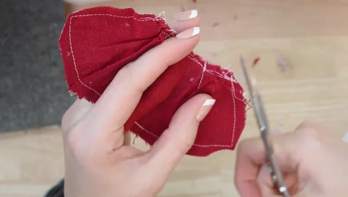 Press the cape, ensuring the bottom opening is neatly folded. Use a hot glue finger guard to avoid burning fingers.