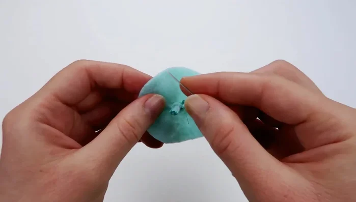 Use a running stitch to sew around the perimeter of the ice cream piece, then pull the thread to gather the fabric into a scoop shape. Fill with stuffing and knot the thread securely.