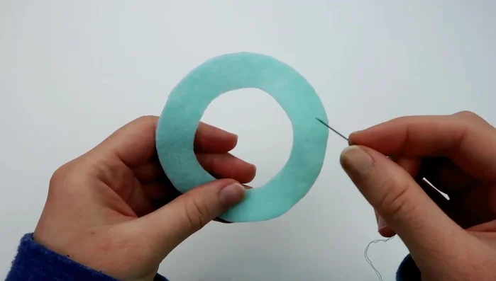 Use a running stitch along the middle of the remaining ice cream piece. Pull the thread to gather the fabric and attach it to the bottom of the ice cream scoop, securing with a knot.