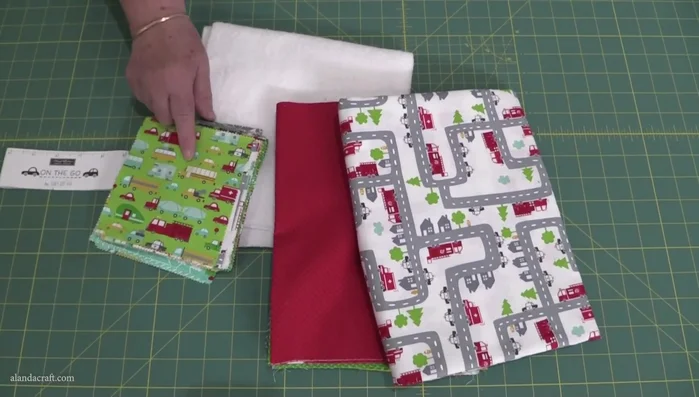 Choose and arrange fabrics: Select a charm pack and coordinating fabrics for the placemats and table runner. Arrange charm squares for each placemat and the table runner, taking a photo to remember the arrangement.