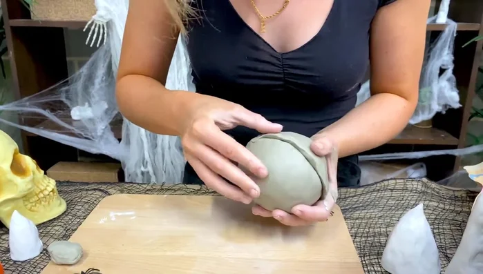 Assemble the pumpkin: Place one bowl on top of the other, ensuring edges match. Smooth the top bowl onto the bottom using your fingertips or wooden tools until a smooth, round ball is formed.