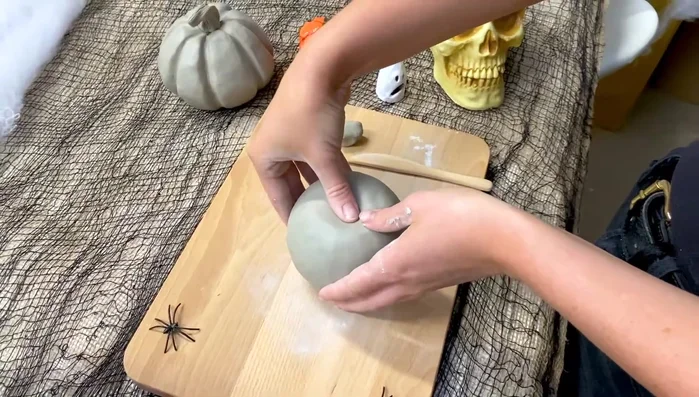 Shape the pumpkin: Use your thumb to indent the top for the stem. Gently press the sides to create a pumpkin shape, not a sphere.