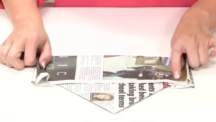 Fold the remaining top section of paper up to match the other folds, creating a crease.