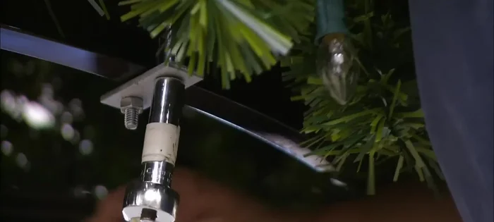 Erect the tree: Bolt the cone of wired greenery to the lower framework and hook the panels of artificial greenery onto the rest of the structure.