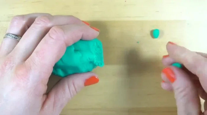 Separate clay into two small pieces and one large piece. Roll each into a ball.