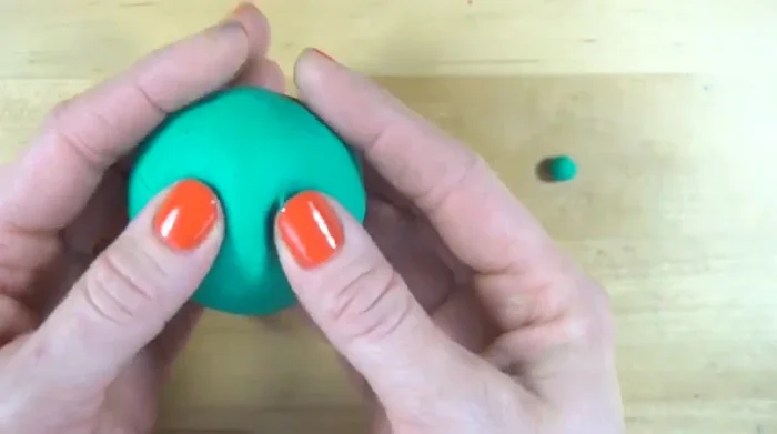 Pull the clay below the eyes upward to form a triangle for the nose.