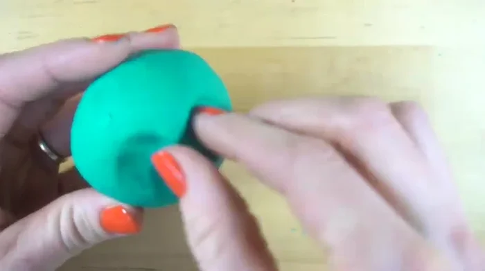 Pull the clay below the eyes upward to form a triangle for the nose.