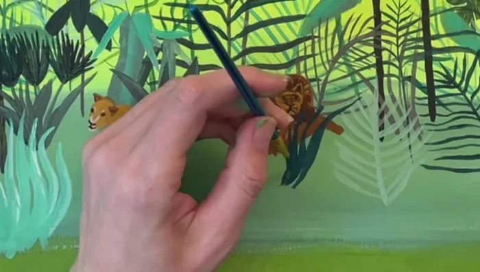 Add tiny blades of grass using light creamy yellow and light teal. Use a tiny brush and water for thin strokes.
