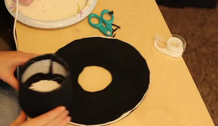 Glue the brim to the wall, aligning the bottom circles and pressing firmly. Hold for several seconds to ensure a secure bond. Place the seam at the back of the hat.