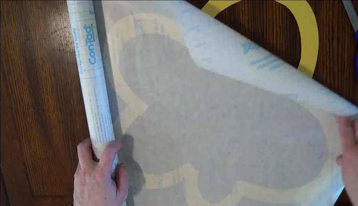 Prepare contact paper: Unroll clear contact paper sticky side up, ensuring enough to cover the flower. Cut the contact paper to size.