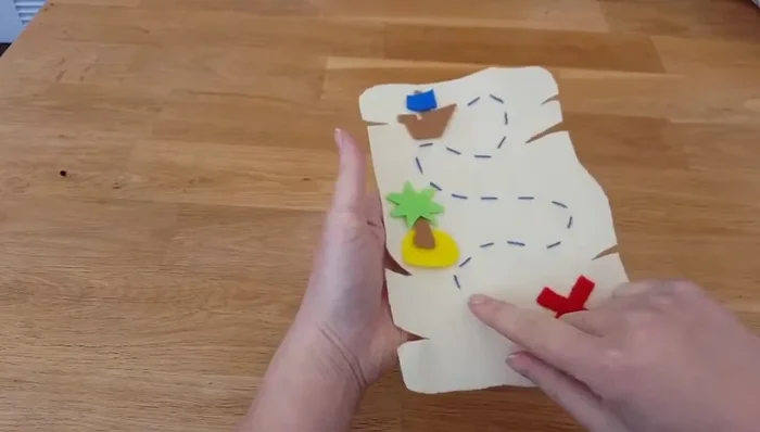 Attach the island and boat pieces one at a time using a matching thread color. Use a felt stitch (shown in the video) for neatness and strength.