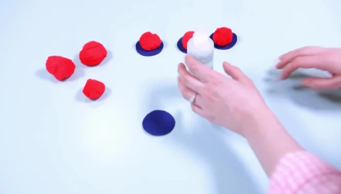 Optional: Pre-glue pom-poms to pieces of self-adhesive felt by dabbing glue onto the felt and pressing it onto the pom-poms.