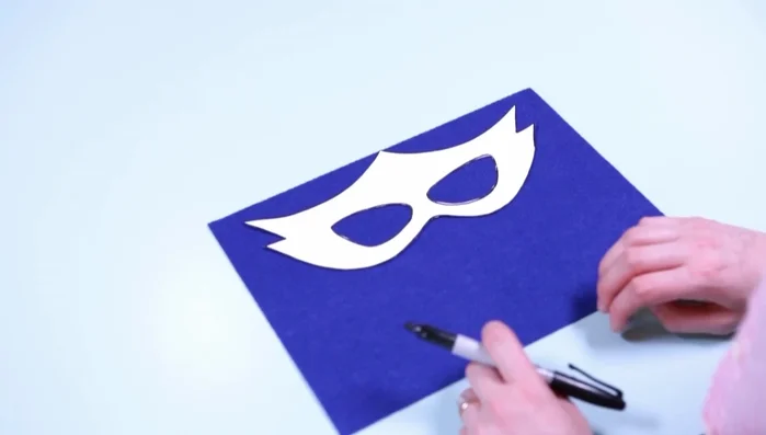 Cut a piece of elastic and attach it to the mask using squares of self-adhesive felt.
