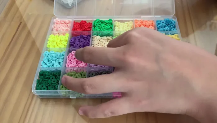 Examining the texture of the clay beads (slightly squishy but firm).