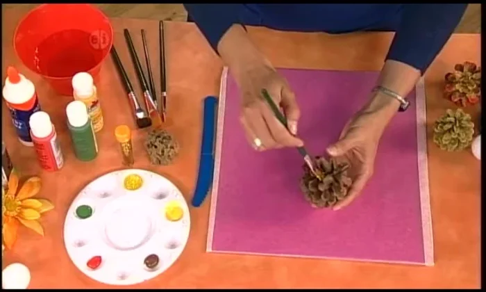 Apply sparkly glue to the tips of the pinecones, then sprinkle with gold glitter. Do this outdoors to minimize mess.