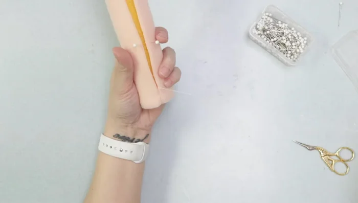 Hand-stitch nylon fleece onto foam body, using a ladder stitch.